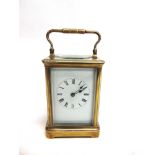 A BRASS CASED CARRIAGE CLOCK the enamel dial with Roman numerals, 10cm wide 15cm high