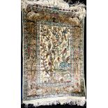 A SMALL SILK PICTORIAL RUG the design incorporating animals on a cream ground, 42.5cm x 63cm