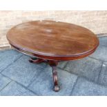 A VICTORIAN MAHOGANY TILT TOP BREAKFAST TABLE the oval top 132cm x 103cm, on tripod base with carved