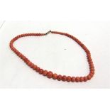 A GRADUATED ROW OF CORAL BEADS the seventy-nine beads of approximately 4/9mm diameter, 45cm long,