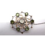 A BIRMINGHAM SCHOOL UNMARKED MOONSTONE AND PERIDOT ARTS AND CRAFTS BROOCH the central cabochon
