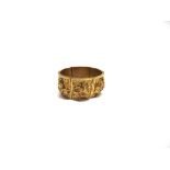 AN INDIAN GOLD CUFF BANGLE composed of six panels embossed in high relief with various deities,