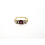 A RUBY AND DIAMOND RING unmarked, the round cut ruby, of approximately 5.7mm by 2.4,, deep,