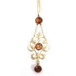 AN EDWARDIAN CITRINE AND SEED PEARL PENDANT stamped '15ct', the central 9mm diameter round cut stone