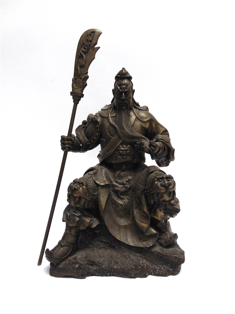 A HEAVY BRONZED METAL FIGURE modelled as a Chinese warrior, seated and holding a pole arm, 51cm