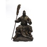 A HEAVY BRONZED METAL FIGURE modelled as a Chinese warrior, seated and holding a pole arm, 51cm