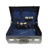 A CASED TRAVELLING TOILET SET with three silver topped glass toilet bottles, a silver backed clothes