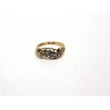 A SAPPHIRE AND DIAMOND 18 CARAT GOLD RING Birmingham 1910, the small central sapphire flanked by