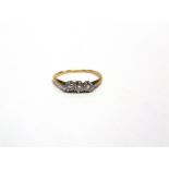 A THREE STONE DIAMOND RING stamped '18ct & PT', the brilliant cuts totalling approximately 0.2