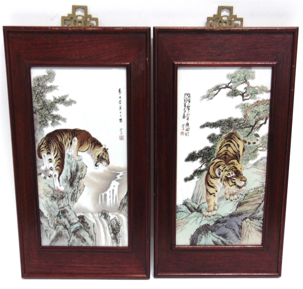 A PAIR OF CHINESE PORCELAIN PLAQUES decorated with scenes of tigers in mountainous landscapes,
