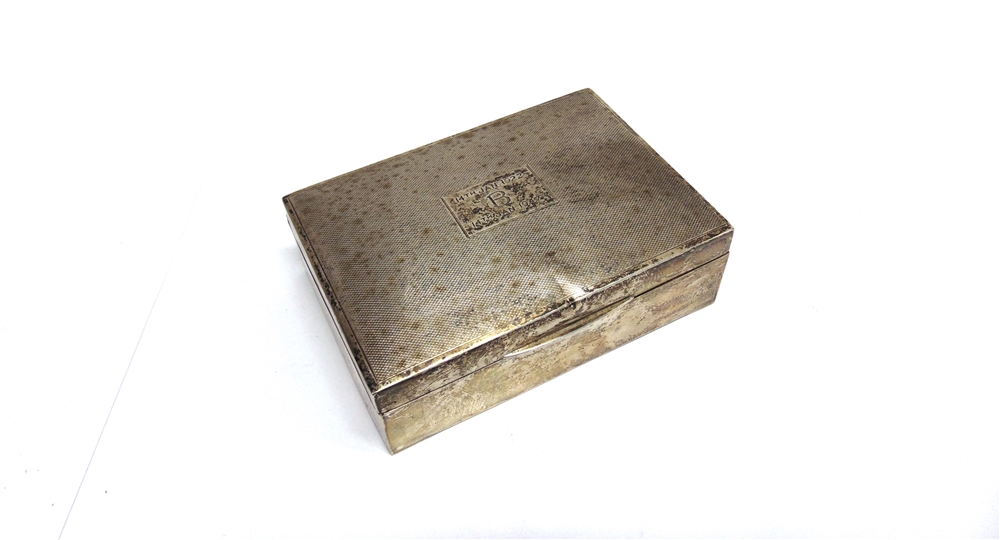 A SILVER CIGARETTE BOX wooden lined, engine turned decoration and inscribed, 12.7cm long
