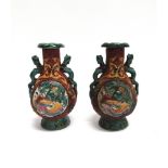 A PAIR OF CHINESE VASES relief decorated with polychrome enamels, stylised animal handles, impressed