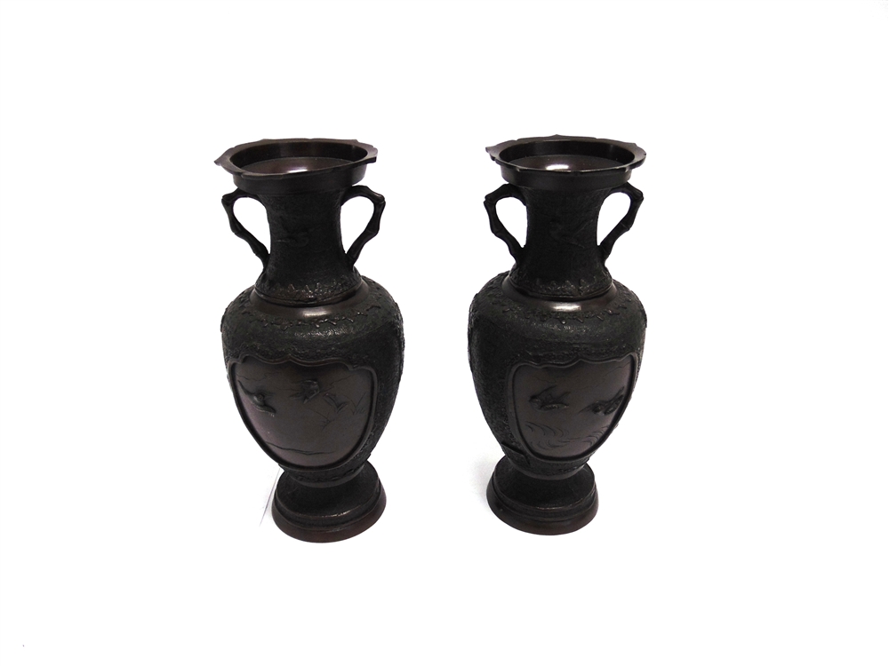 A PAIR OF JAPANESE BRONZE VASES the reserves with relief decoration of pairs of flying birds, six