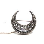 A LATE VICTORIAN DIAMOND CRESCENT BROOCH circa 1890, the silver collet set line of seven graduated