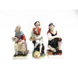 A PAIR OF STAFFORDSHIRE FIGURES the cobbler and his wife, together with another similar