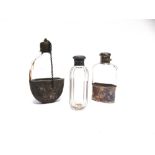 A SILVER MOUNTED GLASS HIP FLASK London 1910 with captive bayonet top, pull off cup base, 11cm long;