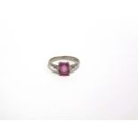 A PINK SAPPHIRE AND DIAMOND THREE STONE PLATINUM RING the step cut stone, 6.9mm by 5.4mm by 2.8mm