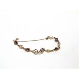 A 9 CARAT GOLD BRACELET the five stones alternate set with circular and figure of eight links,