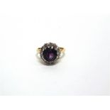 AN AMETHYST AND DIAMOND 18 CARAT GOLD CLUSTER RING the round cut stone, measuring approximately 8.