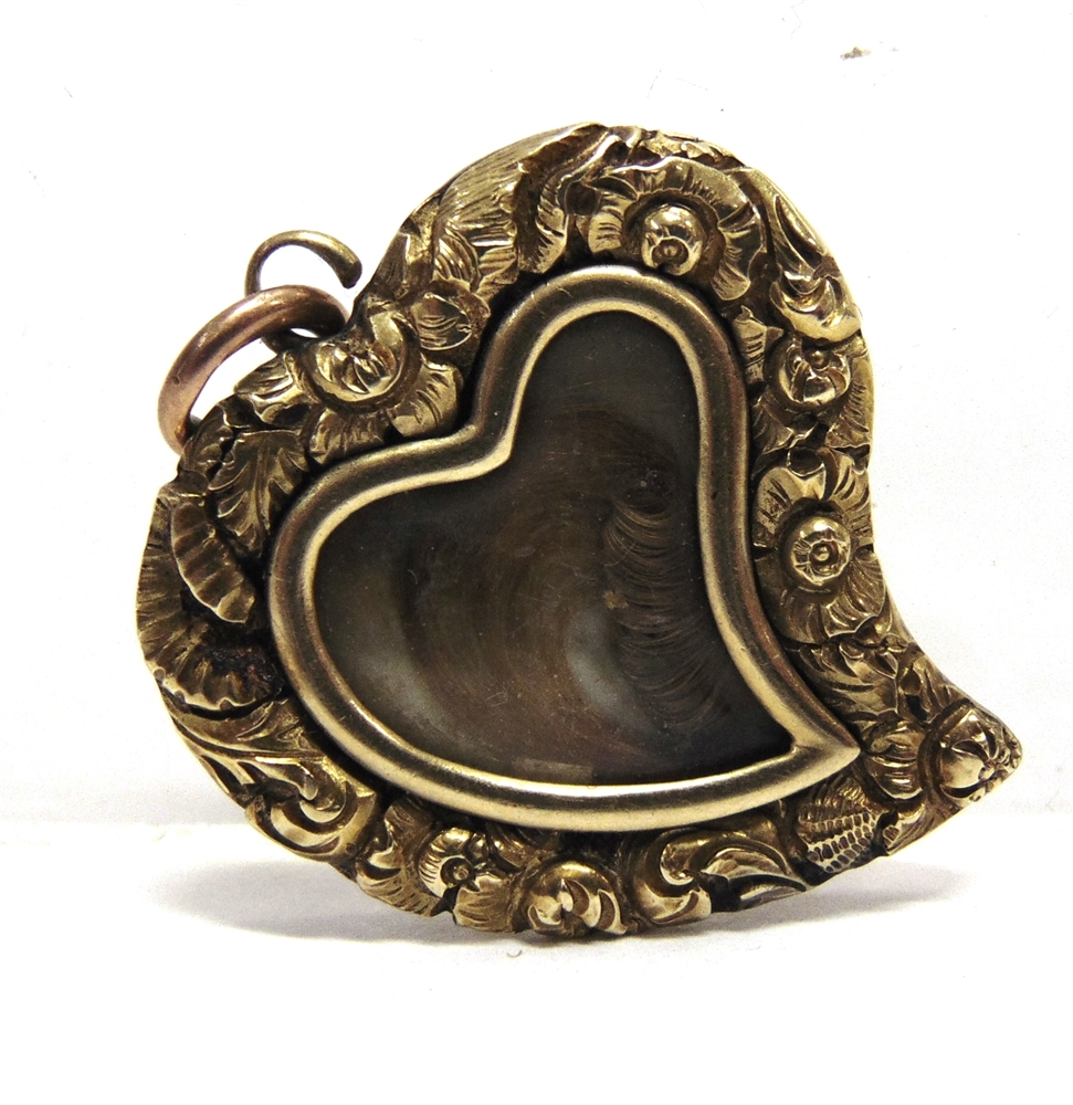 A LATE VICTORIA MOURNING LOCKET of heart shape with a glazed centre containing hair, foliate