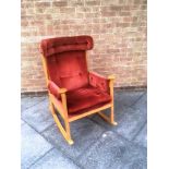 A PARKER KNOLL BEECH FRAMED ROCKING CHAIR the arms capped with roundels, model PK 1031/5