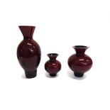 THREE MATCHING CAITHNESS GLASS VASES in red/black colourway, the largest 27cm high