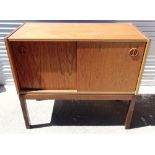 A 1960S DANISH TEAK CABINET the sliding doors inset with circular handles, raised on square legs,