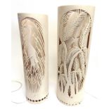 TWO MATCHING CYLINDRICAL RESIN FLOOR LAMPS with relief cut decoration, 69cm and 74cm high