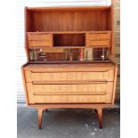 A DANISH TEAK BUREAU CHEST with brushing slide, the upper section with shelves and four drawers