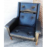 A DANISH BLACK LEATHER UPHOLSTERED LOUNGE ARMCHAIR on exposed oak frame