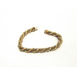 A BRACELET stamped ;750', of hollow rope links wrapped with a white box link chain, 18c, long, 15.9g