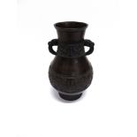 A CHINESE BRONZE VASE with pair of mask handles, three bands of relief decoration, 31cm high