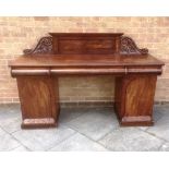 A VICTORIAN FIGURED MAHOGANY TWIN PEDESTAL SIDEBOARD with carved decoration and three moulded frieze