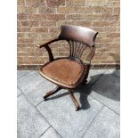 AN EDWARDIAN OAK REVOLVING OFFICE CHAIR with pierced splat back, upholstered seat on quatrefoil