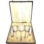 A FIVE PIECE SILVER DRESSING TABLE SET Birmingham 1938, comprising a hand mirror, two hair