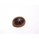 A VICTORIAN GARNET CARBUNCLE BROOCH with a diamond set starburst centre, 2.2cm long, 6.9g gross