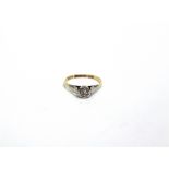 A SINGLE STONE ILLUSION SET DIAMOND RING stamped '18ct & Plat', finger size O. 1.9g gross