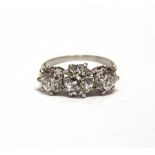 A THREE STONE DIAMOND RING the white mount unmarked, the old brilliant cut diamonds of approximately
