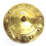 A CIRCULAR BRASS DHAL STYLE SHIELD the smooth face with a central spike and studwork surround, the