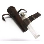 A TAPERED GLASS FLASK with silver mount and leather holder for saddle mounting, length of case 22cms