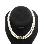 A TWO ROW UNIFORM PEARL NECKLACE the 59/55 pearls of approximately 6.9-7.3mm diameter, to a gilt