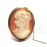 A 9 CARAT GOLD MOUNTED SHELL CAMEO BROOCH of a female in profile, 4cm long, 11g gross