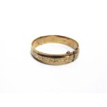 A 9 CARAT GOLD HINGED BANGLE with engraved central section, inner diameter 5.8cm, 16g gross