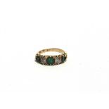 A FIVE STONE EMERALD AND DIAMOND RING stamped '9ct', the three graduated emeralds with brilliant