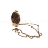 A 9 CARAT GOLD OVAL LOCKET with engraved decoration, 4.4cm long excluding the bale on a chain,