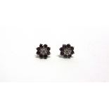 A PAIR OF DIAMOND AND AMETHYST CLUSTER 18 CARAT GOLD EARSTUDS the central brilliant cut of