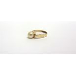 A SINGLE STONE CULTURED PEARL RING the 7.3mm pearl to a yellow mount indistinctly marked but tests