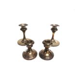 A PAIR OF LOADED SILVER DESK CANDLESTICKS 10cm high; with a smaller pair of loaded silver desk