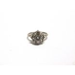 A NINE STONE DIAMOND CLUSTER RING the white mount stamped 'Plat', the central brilliant cut of