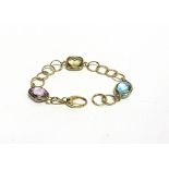 A BRACELET, STAMPED '750' AND 'LE GI' set at intervals with an amethyst, blue topaz and citrine,